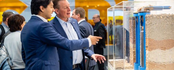 Männer stehen vor einem Messestand der ISH.